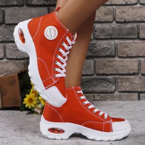 Vibrant orange high-top canvas sneakers with thick platform soles and air cushions.