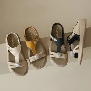 Makroansicht von stilvollen Plateausandalen mit Strasssteinen in Schwarz, Beige und Gelb