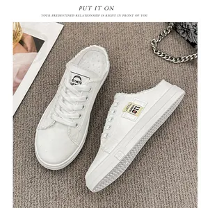 Detalle de zapatillas de lona blancas sin talón con bordes deshilachados y cordones