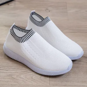Dettaglio di sneaker bianche in fly-knit traspiranti con colletto a coste a righe
