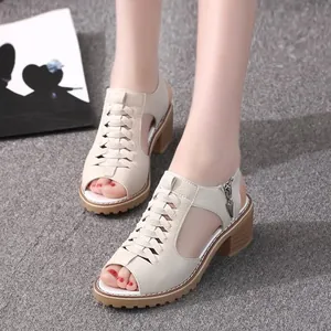 Stylish women's beige hollow block heel peep-toe sandals in Roman style on a grey floor