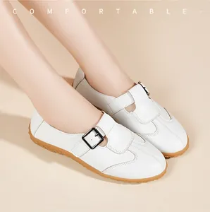 Nahaufnahme weißer Retro-Flachschuhe im Mary Jane Stil mit Schnalle und Gummisohle