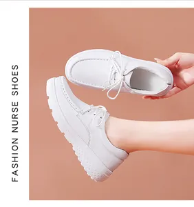 Dettaglio di scarpe da infermiera bianche stringate con spesse suole antiscivolo.