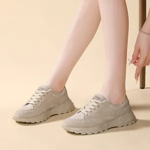 Primo piano di scarpe dad beige da donna con inserti in mesh e suole spesse ai piedi