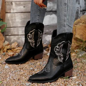 Retro style black Western cowboy boots featuring intricate white embroidery and block heels