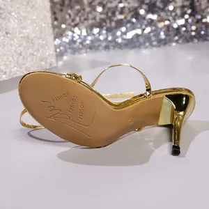 Detail view of gold stiletto sandal showing the sole and elegant high heel profile.