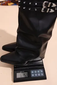 Dettaglio del peso degli stivali alti neri con borchie in stile vintage retrò