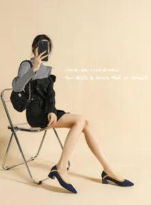 Detail view of navy knit pointed-toe block heel pumps with yellow piping accents
