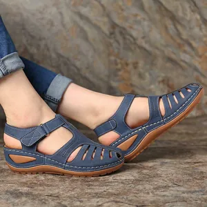 Nahaufnahme von blauen Vintage-Keilsandalen für Damen mit modischem hohlem Design