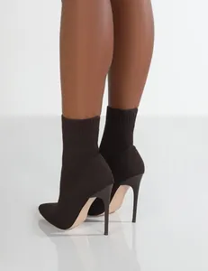 Detaillierte Rückansicht eleganter dunkelbrauner Stiletto-Socken-Stiefeletten am Bein