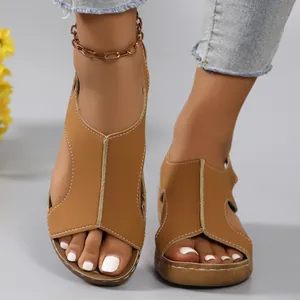 Detail view of tan wedge sandals with soft thick soles and stylish white stitching.
