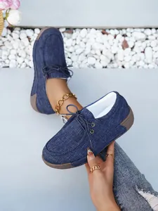 Detailansicht der dunkelblauen Denim-Canvas-Slipper mit Plateausohle und Schnürung