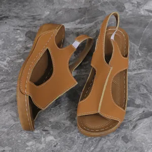 Detail view of brown wedge sandals with soft polyurethane thick sole on marble background