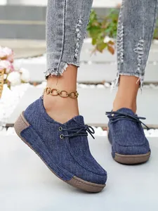 Detailaufnahme von blauen Damen-Loafern aus Denim mit dicker Plateausohle und Schnürung