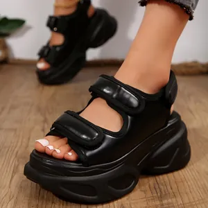 Détail de sandales noires à semelles compensées avec bandes velcro pour le style d'été