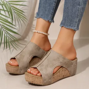 Close-up view of women's platform wedge sandals with rivet details and peep toe style.