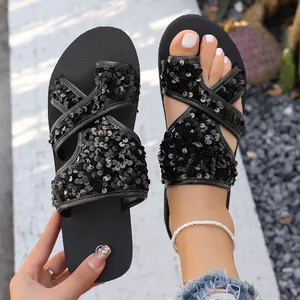 Gros plan de sandales plates à paillettes noires pour femmes, style décontracté