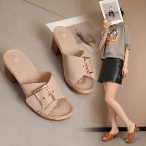 Detailed view of beige high-heel mules featuring a stylish gold metal buckle strap