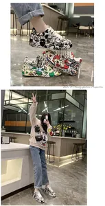 Primo piano di sneakers platform graffiti alla moda e modella che indossa le scarpe in un caffè.