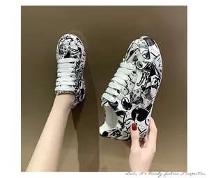 Vista dettagliata delle scarpe da ginnastica graffiti bianche e nere con suola spessa