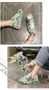 Dettaglio dei vivaci motivi graffiti con cuori e carte sulle sneakers platform da donna