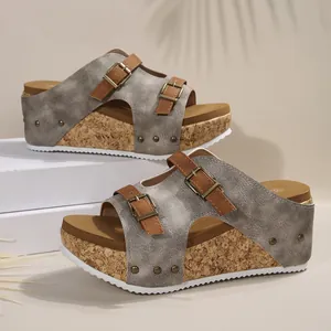 Détail des mules à plateforme en liège pour femmes avec deux brides à boucles et cuir gris