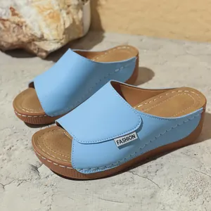 Detail view of light blue platform wedge slides with white decorative stitching