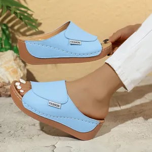 Close-up of light blue women's platform wedge slippers with stylish white stitching.
