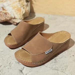 Detailed side view of brown thick-sole wedge slippers with peep toe and stitch accents.