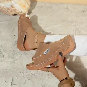 Close-up view of taupe women's platform slide sandals with white stitching detail