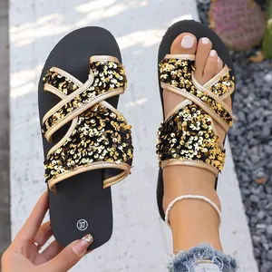 Gros plan sur des sandales à paillettes dorées pour femmes avec semelle souple de plage