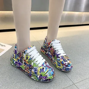 Vista dettagliata delle sneakers platform da donna con vivace stampa graffiti e lacci bianchi