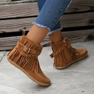 Vista detallada de botines de ante marrón para mujer con flecos y tachas doradas