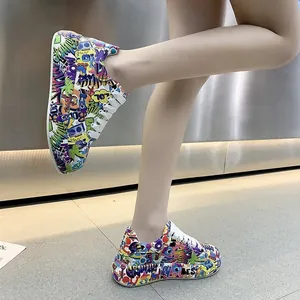 Dettaglio ravvicinato di sneaker platform con stampa graffiti multicolore e lacci bianchi