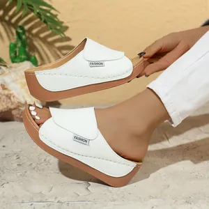 Close-up detail of white wedge platform slippers featuring a minimalist fashion label