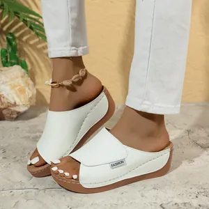 Detail of white thick-sole wedge slides with a comfortable peep-toe design.