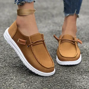 Vista dettagliata delle scarpe slip-on in tela a coste marroni su fondo di ghiaia
