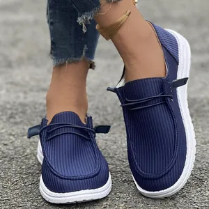 Primo piano di mocassini da donna in tessuto blu navy con suola bianca strutturata