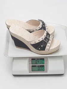 Vue détaillée d'une sandale à semelle compensée pesant exactement 0,430 kg sur une balance