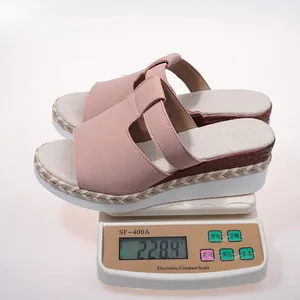 Lightweight pink platform wedge sandals being weighed on a scale showing 228.4g