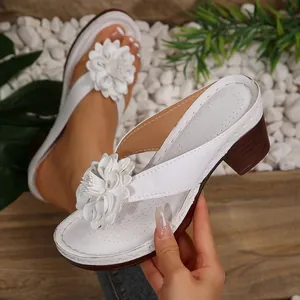 Detailed view of white wedge thong sandals featuring an elegant large 3D flower decoration.