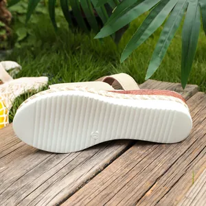 Detailed macro view of white anti-slip sole and braided wedge heel on beige sandal