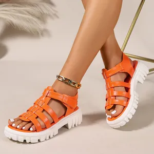 Detailed view of trendy orange gladiator sandals featuring a chunky white serrated platform sole