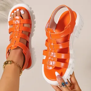 Detailed view of vibrant orange platform gladiator sandals with chunky white lug soles.