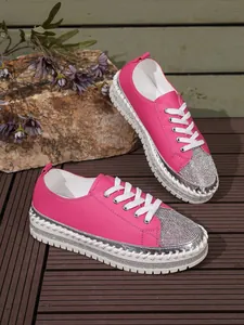 Close-up of pink women's sneakers featuring rhinestone toe and thick platform sole