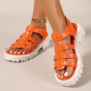Detailed view of orange roman platform sandals featuring a chunky white lug sole