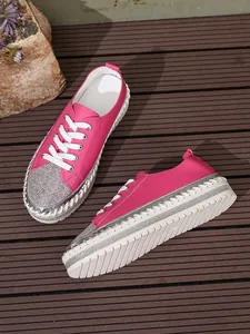 Detailed shot of pink fashion sneakers featuring rhinestone toes and platform soles