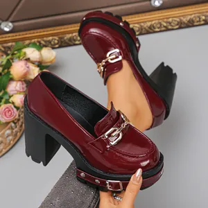 Nahaufnahme von weinroten Gothic-Plateau-Heels aus Lackleder mit Metallkette
