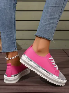 Detail view of stylish pink rhinestone platform sneakers with white decorative stitching