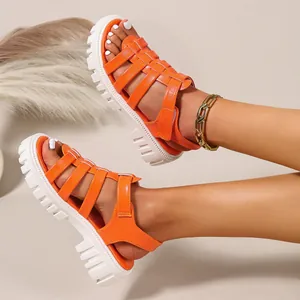 Close-up detail of vibrant orange gladiator sandals featuring a chunky white lug sole.